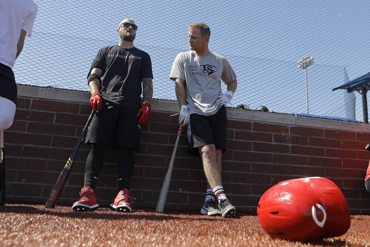 Cincinnati Reds' Tucker Barnhart, left, talks with Josh VanMeter during a workout at Grand Park ...