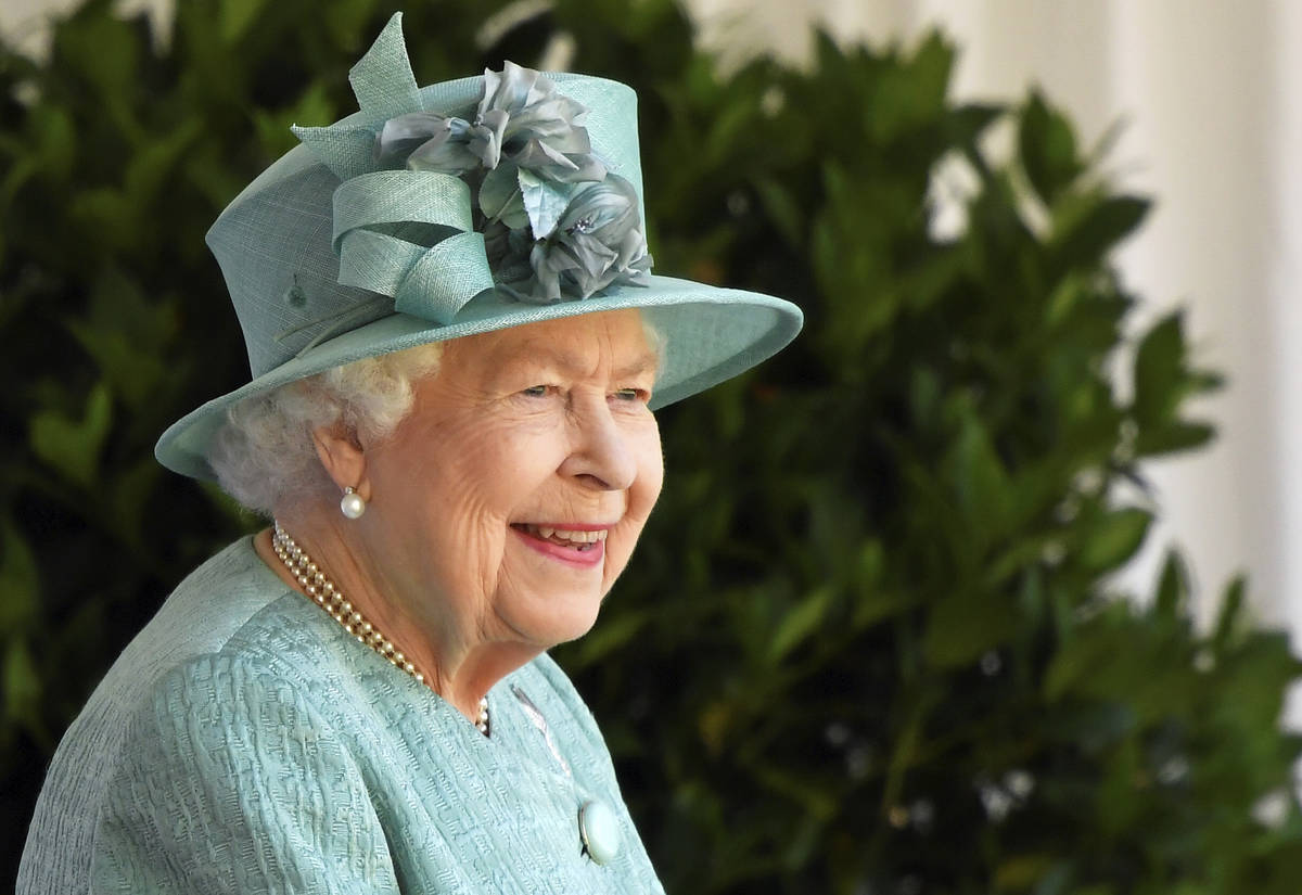 Britain's Queen Elizabeth II reacts as she looks out during a ceremony to mark her official bir ...