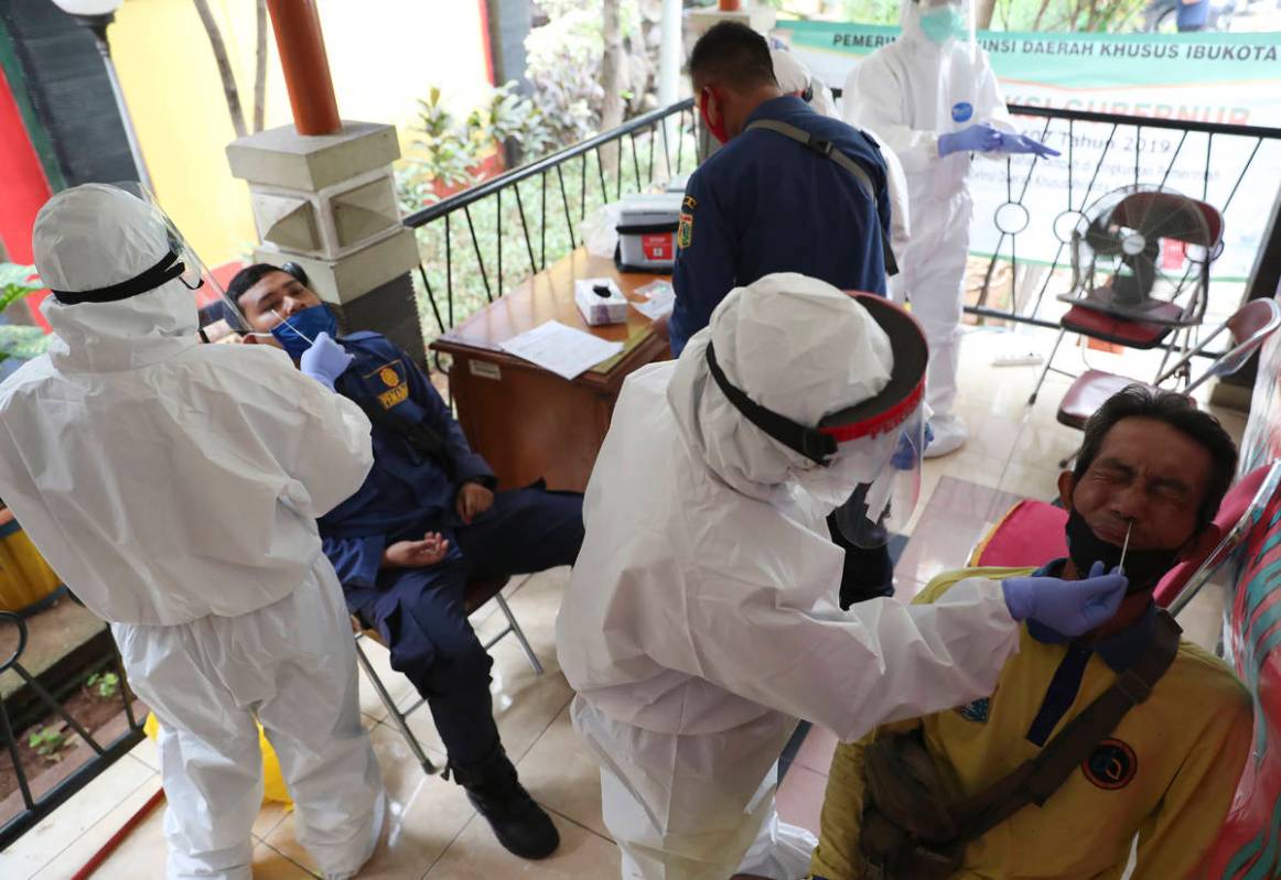 Health workers take nasal swab samples during a public testing for the new coronavirus conducte ...