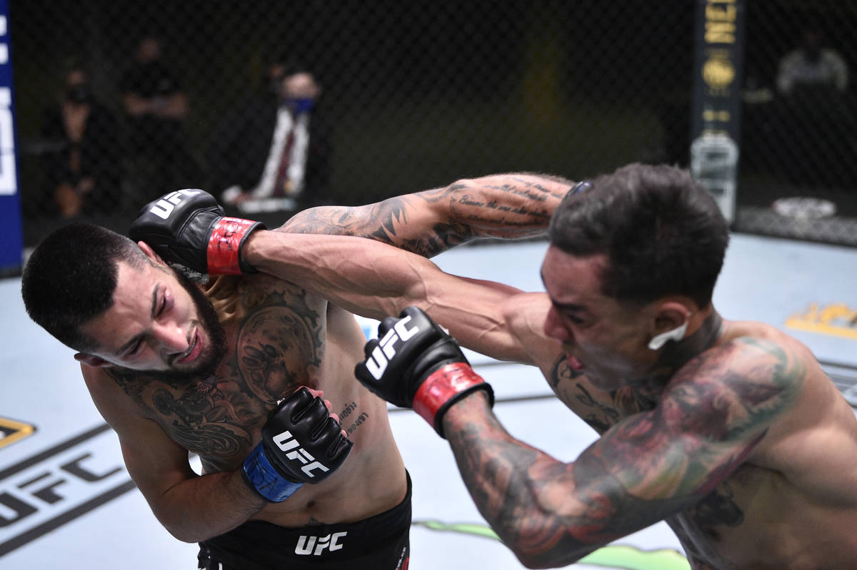 Charles Jourdain of Canada and Andre Fili trade punches in their featherweight fight during the ...
