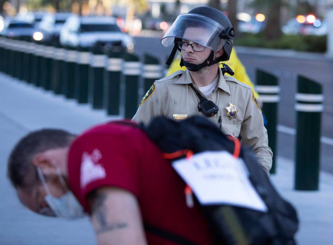 A legal observer writes down information as police don riot gear at a protest against police br ...