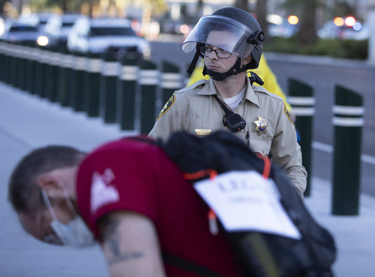 A legal observer writes down information as police don riot gear at a protest against police br ...