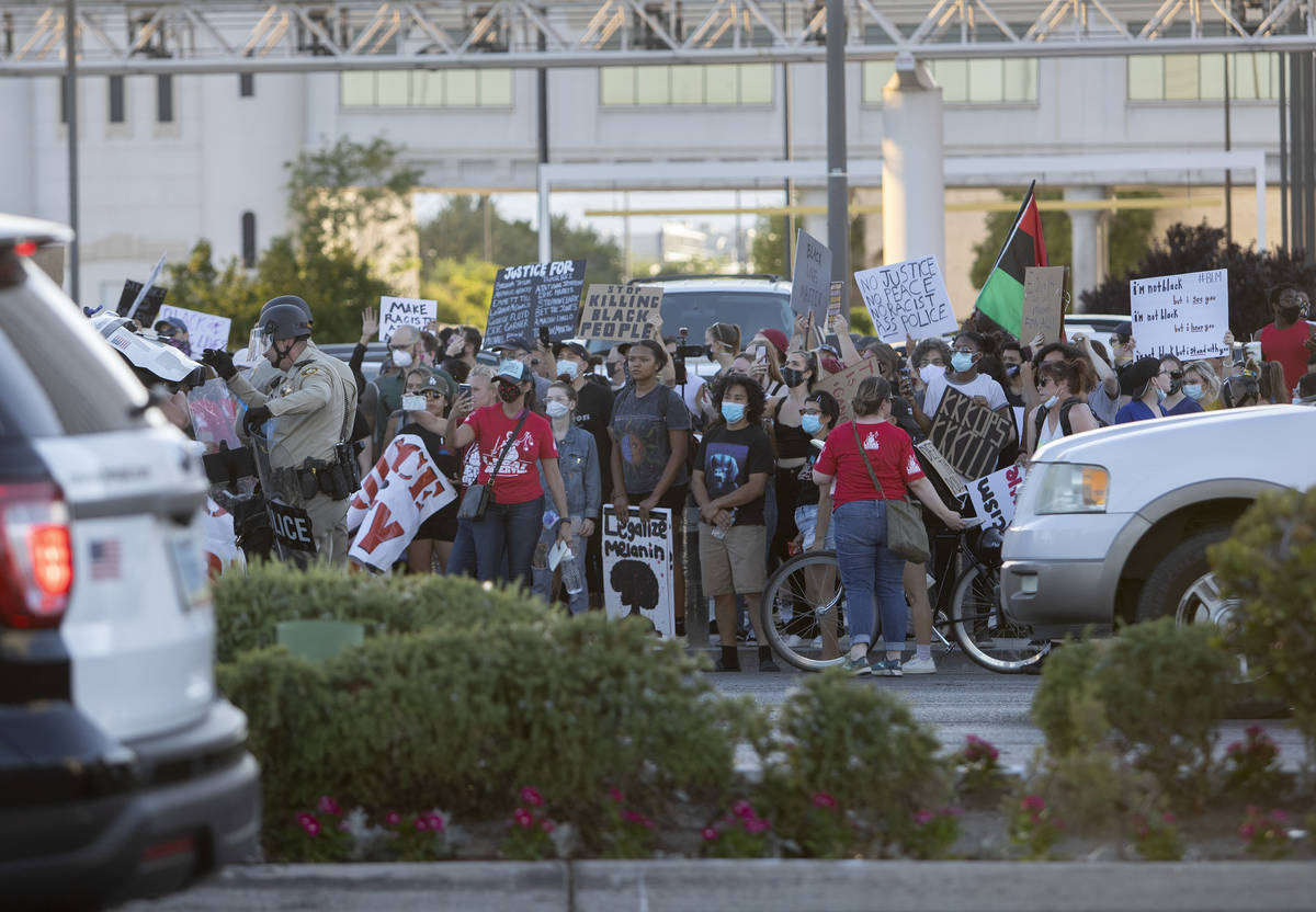 Legal observers stand in front of protesters as they make their way down Las Vegas Boulevard, m ...