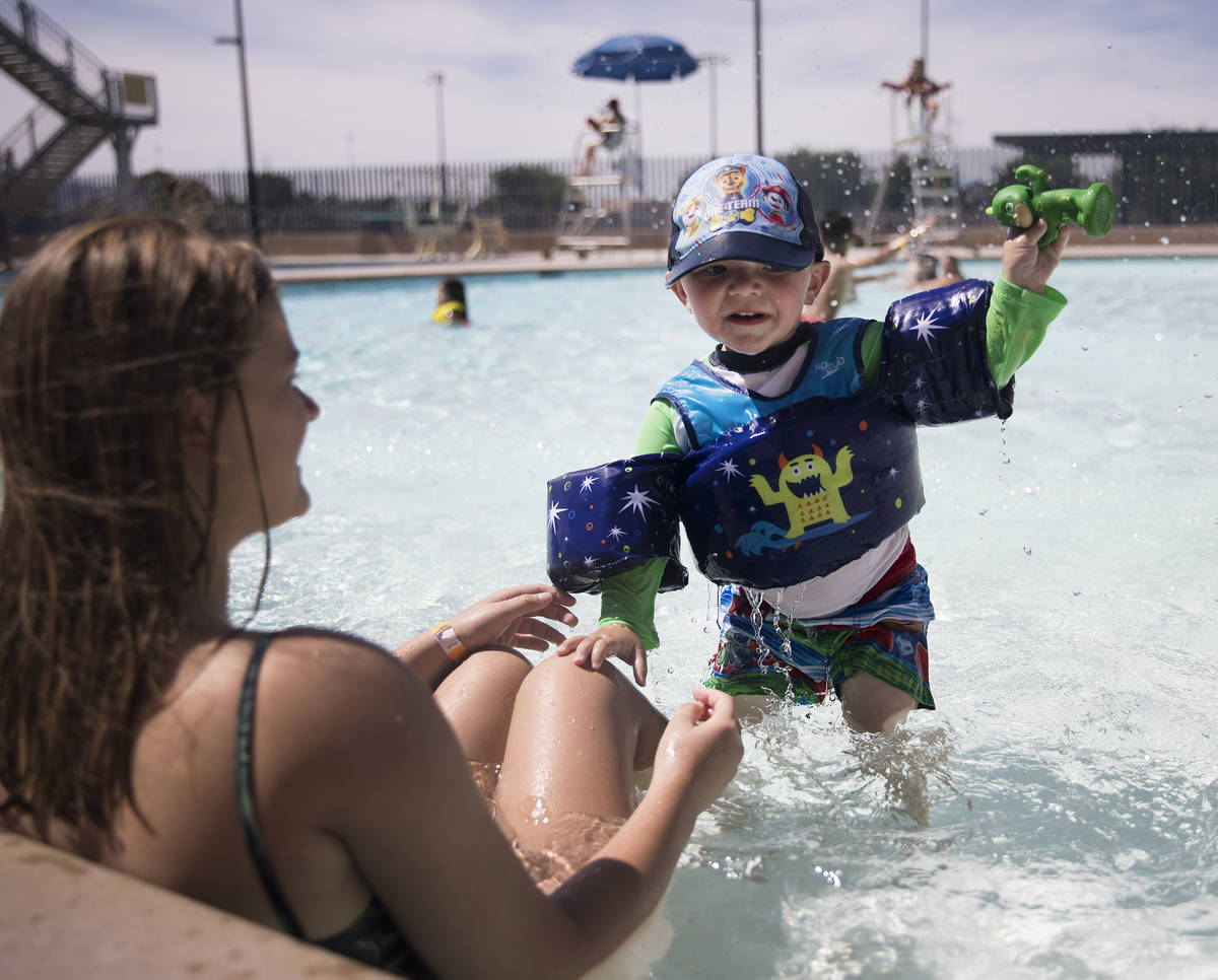 Lucas Goheen, 2, center, plays with his sister Ireland Goheen, 14, at Garside Pool in Las Vegas ...