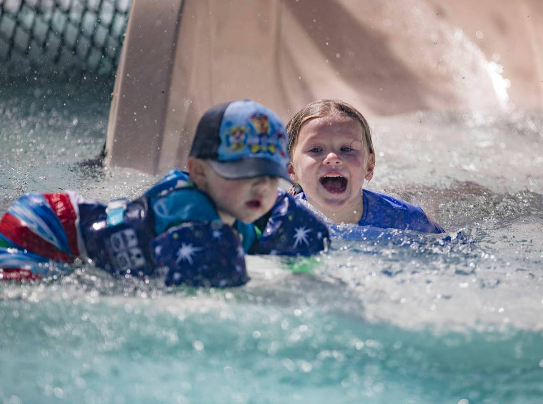 Siblings Lucas Goheen, 2, left, and Riley Goheen, 5, right, on the water slide at Garside Pool ...