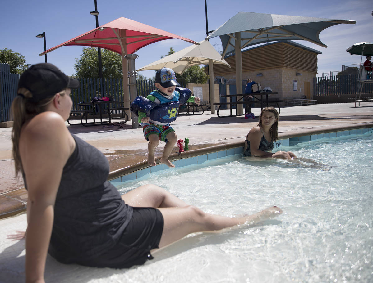 Allison Goheen, left, watches her son Lucas Goheen, 2, jump in the pool next to his sister Irel ...