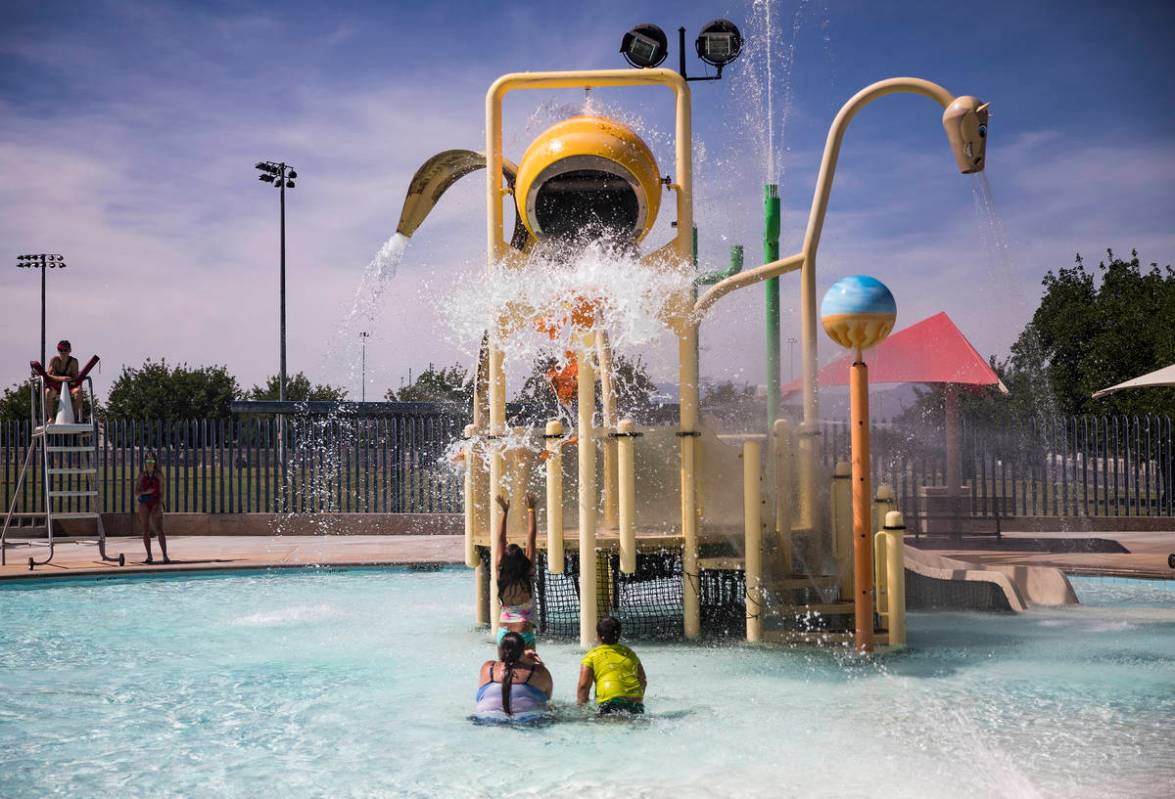 Swimmers await a bucket of water to fall from the water park at Garside Pool in Las Vegas, Mond ...