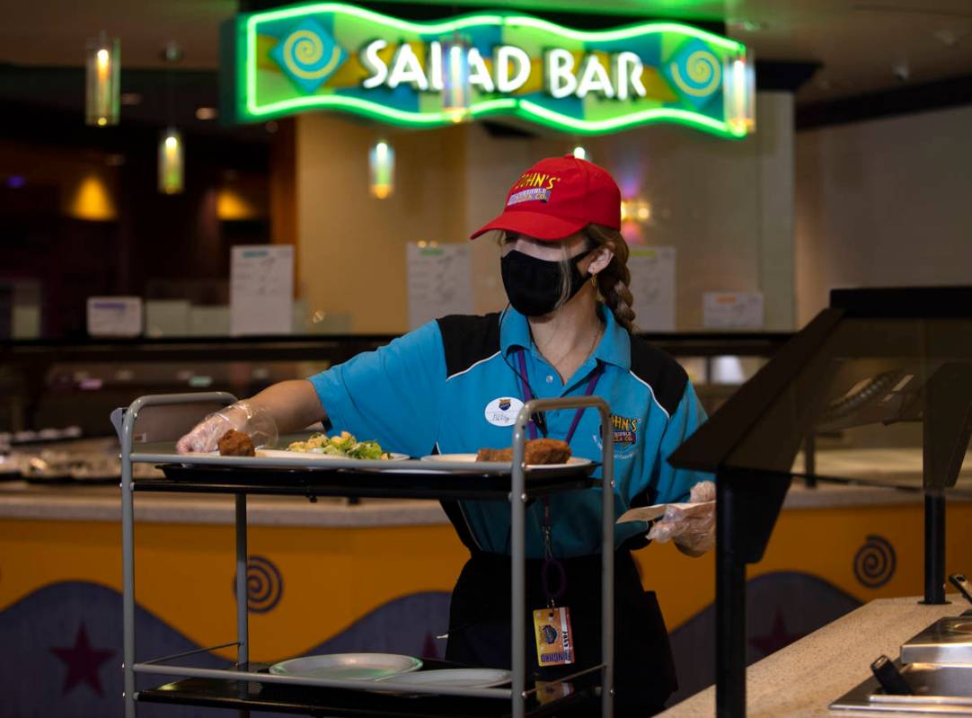 Abigail Gonzalez loads a cart with a table's order from the buffet at John's Incredible Pizza o ...