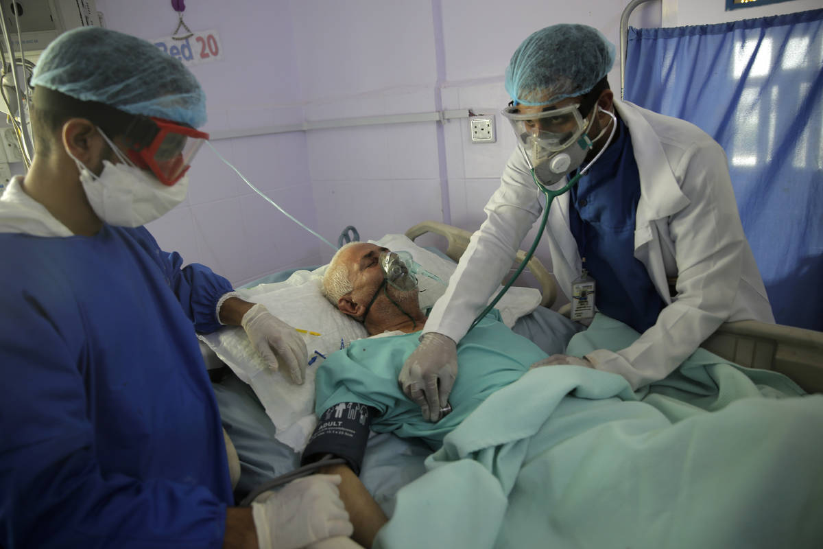 FILE - In this Sunday, June 14, 2020 file photo, medical workers attend to a COVID-19 patient i ...