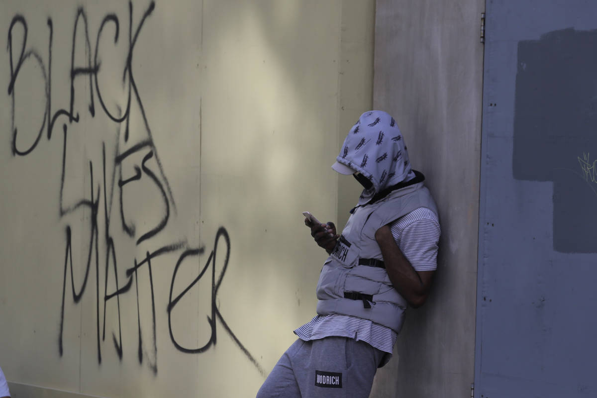 A member of Black Lives Matter movement, uses his mobile phone following a protest in central L ...