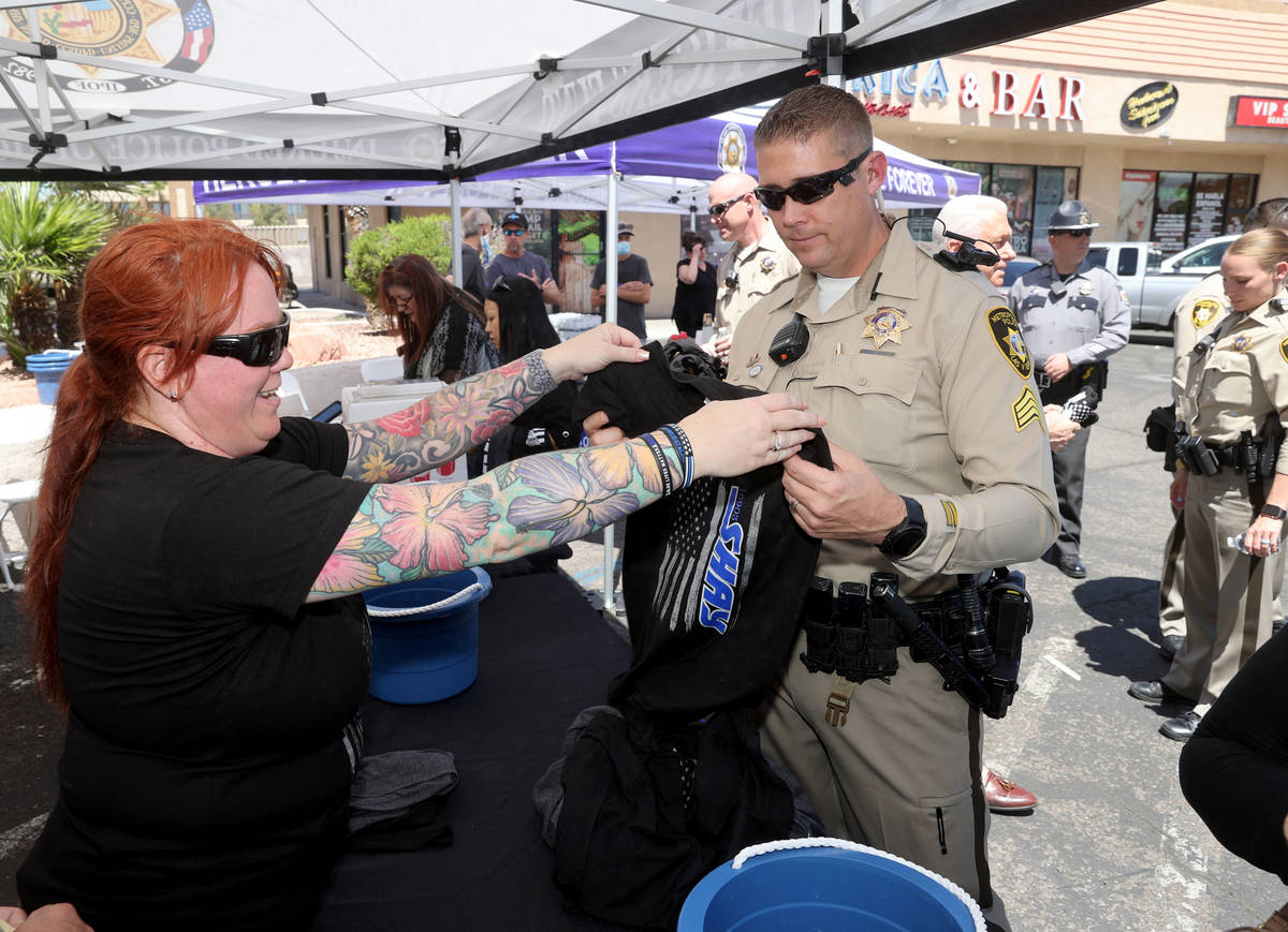 Las Vegas police officer Christina Pettit helps Matt Dannenberger buy a T-shirt during a fundra ...