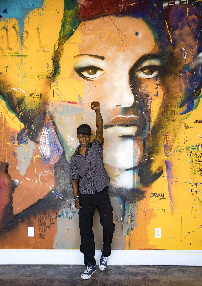 Dray stands in front of his mural of Kathleen Cleaver, a Black Panthers organizer, at Alt-Rebel ...