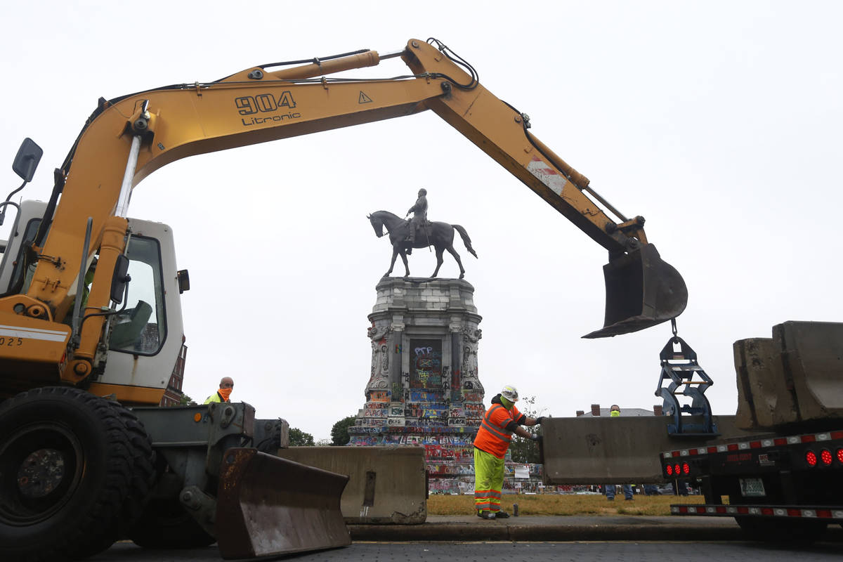 Workers for The Virginia Department of General Services install concrete barriers around the st ...