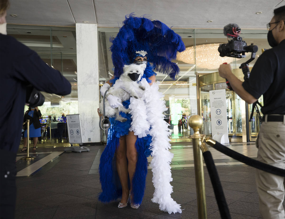 Jennifer Romas, from the Sexxy show, greets guests with the dog Sir Winston of Westgate at the ...