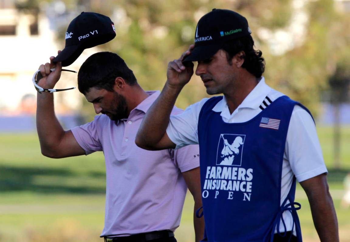 Kyle Stanley, left, and his caddie Brett Waldman walk off the 16th green where Stanley lost a p ...