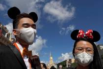 Visitors wearing face masks to prevent the spread of the new coronavirus, attend a reopening ce ...