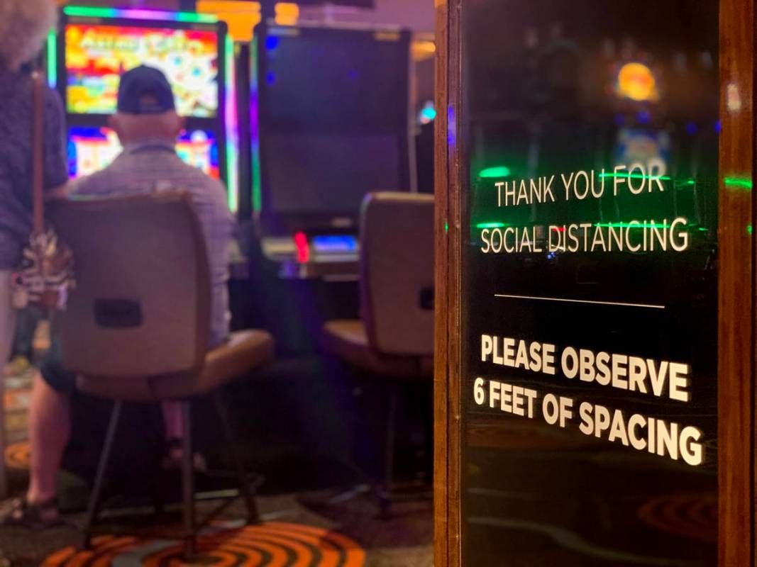 A sign calling for social distancing is seen as individuals play games at Gila River Casino at ...