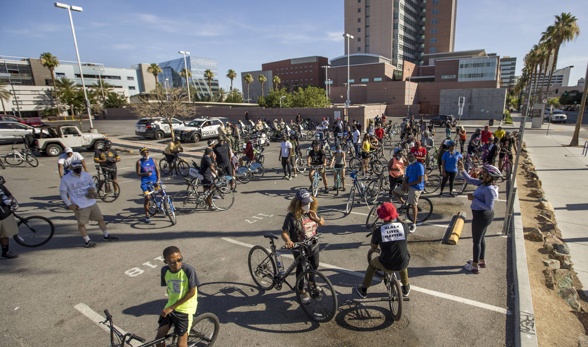Participants in a Black Lives Matter bike ride against injustice gather in a parking lot off of ...