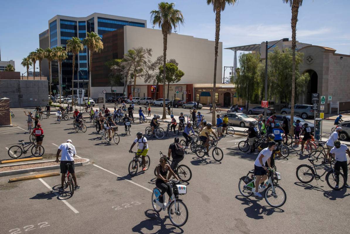 Participants in a Black Lives Matter bike ride against injustice return to a parking lot off of ...