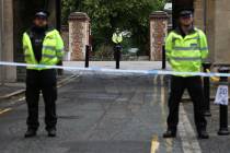 Police stand guard at the Abbey gateway of Forbury Gardens park in Reading town centre followin ...