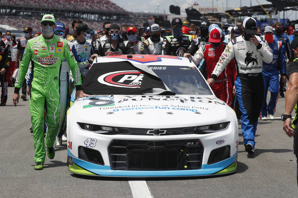 Nascar drivers Kyle Busch, left, and Corey LaJoie, right, join other drivers and crews as they ...