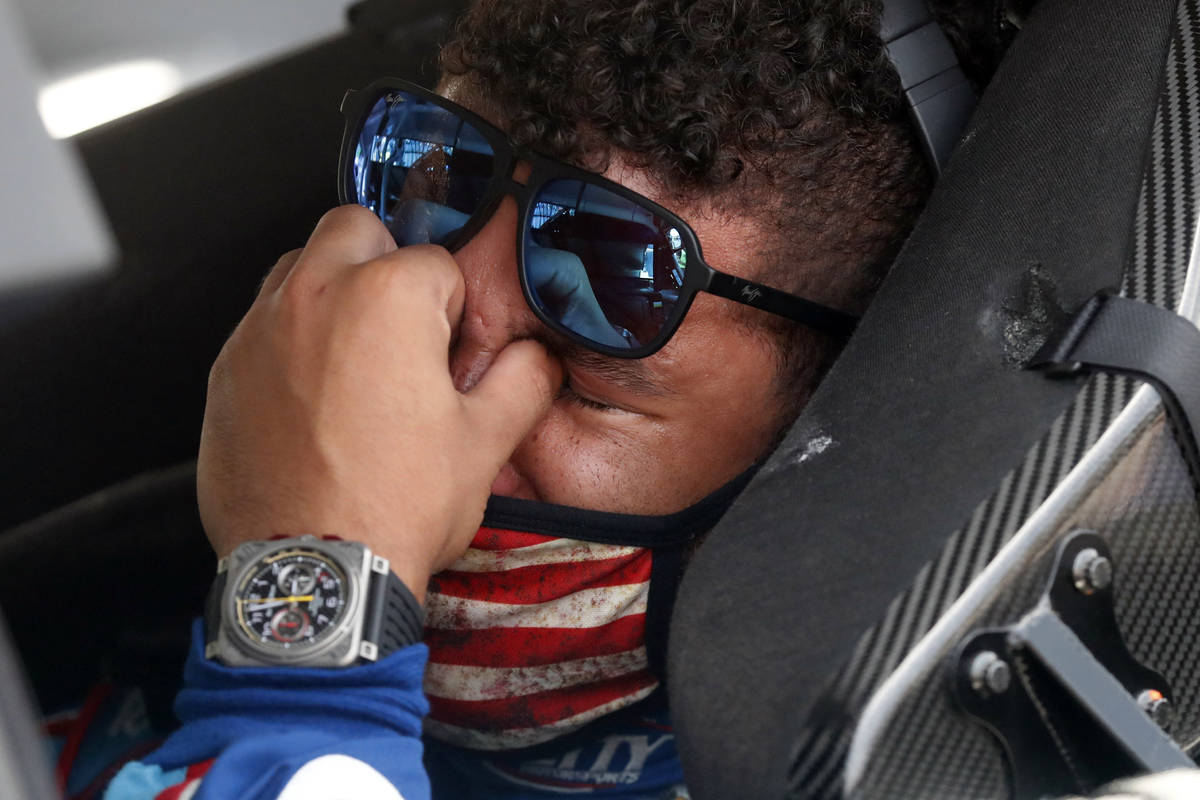 Driver Bubba Wallace, right, is overcome with emotion as he sits in his car prior to the start ...