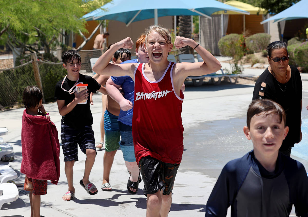 A group of friends run to their next ride on opening day at Wet 'n' Wild water park in Las Vega ...