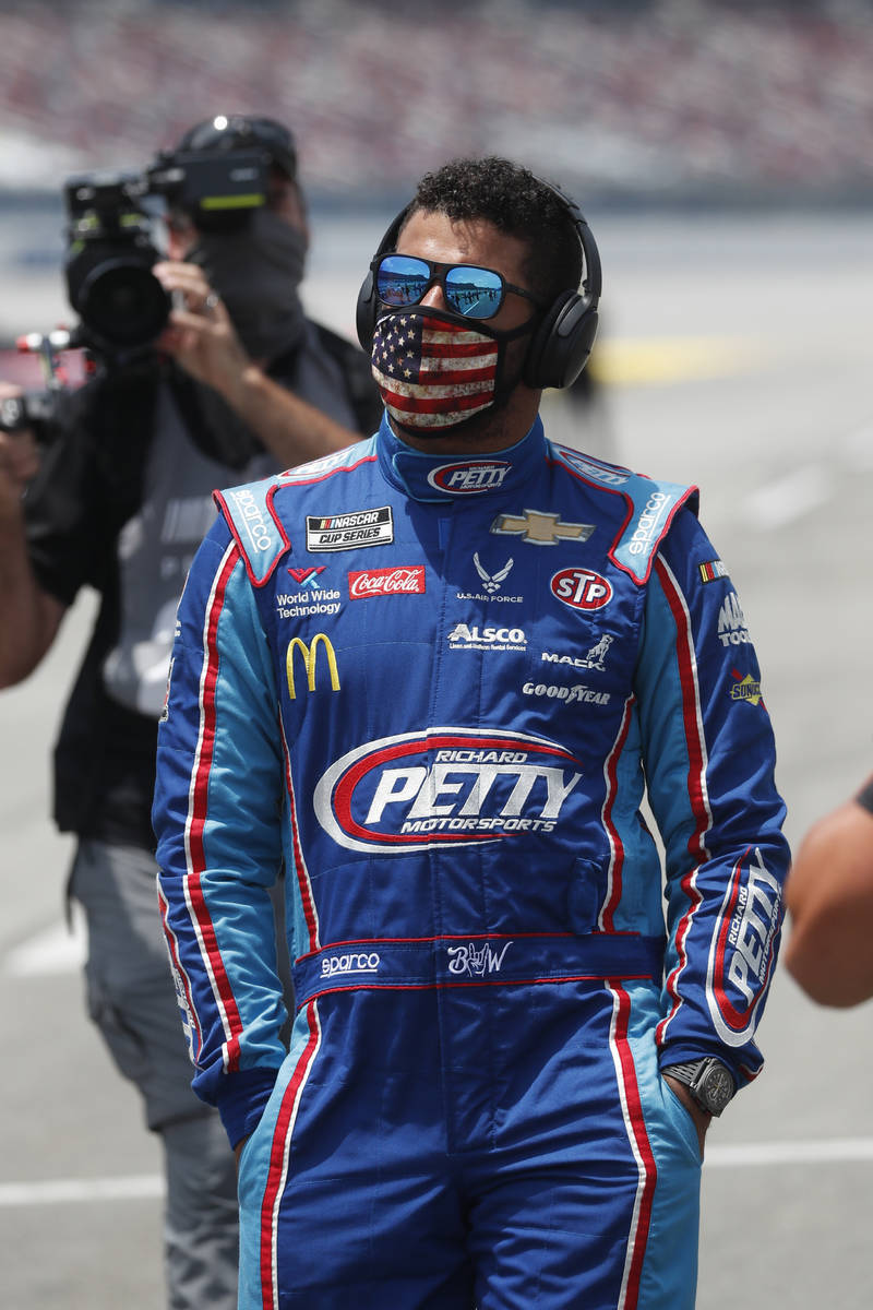 Driver Bubba Wallace walks to his car in the pits of the Talladega Superspeedway prior to the s ...