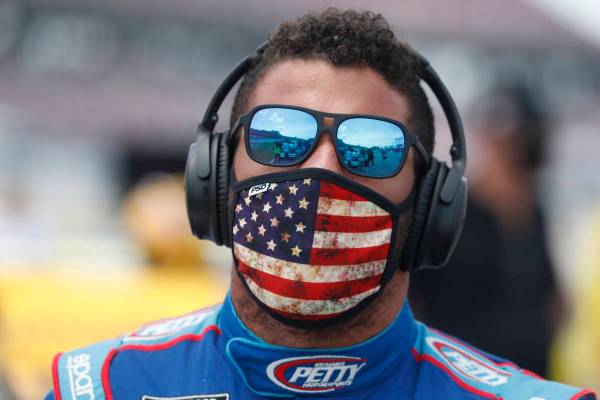 Driver Bubba Wallace walks to his car in the pits of the Talladega Superspeedway prior to the s ...