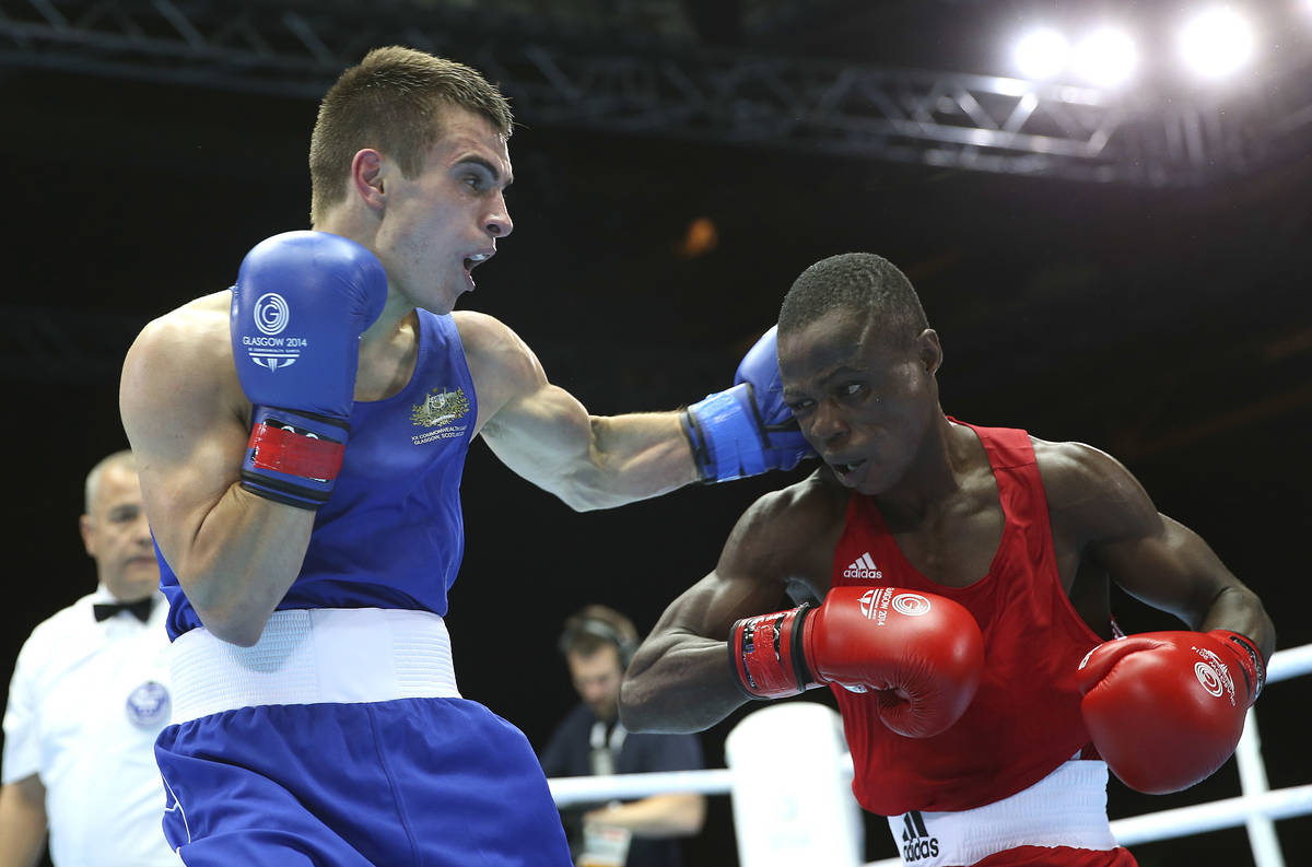 Australia's Andrew Moloney, left, lands a left hook on Nigeria's Wasiu Taiwo during their men's ...