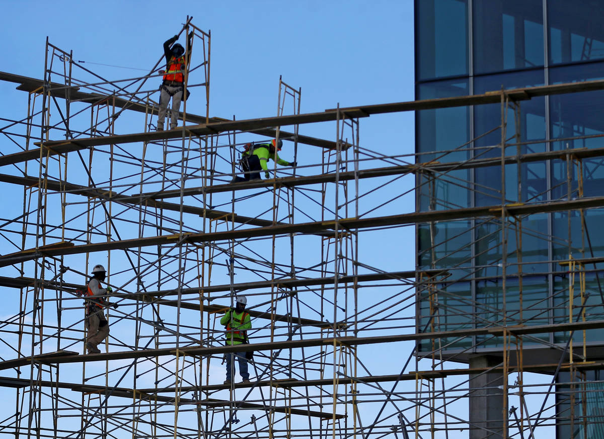Workers remove scaffolding on the west side of the Las Vegas Convention Center expansion projec ...