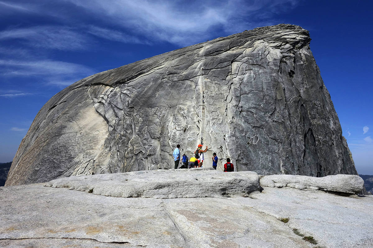 File - In this July 15, 2014, file photo, hikers gather in the foreground as climbers use the a ...