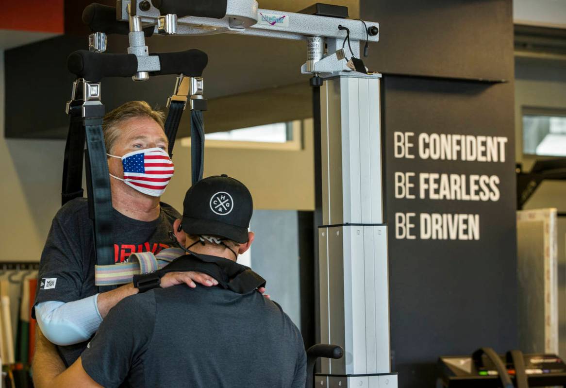 Quadriplegic IndyCar team owner Sam Schmidt, left, is given neuromuscular electrical and vibrat ...