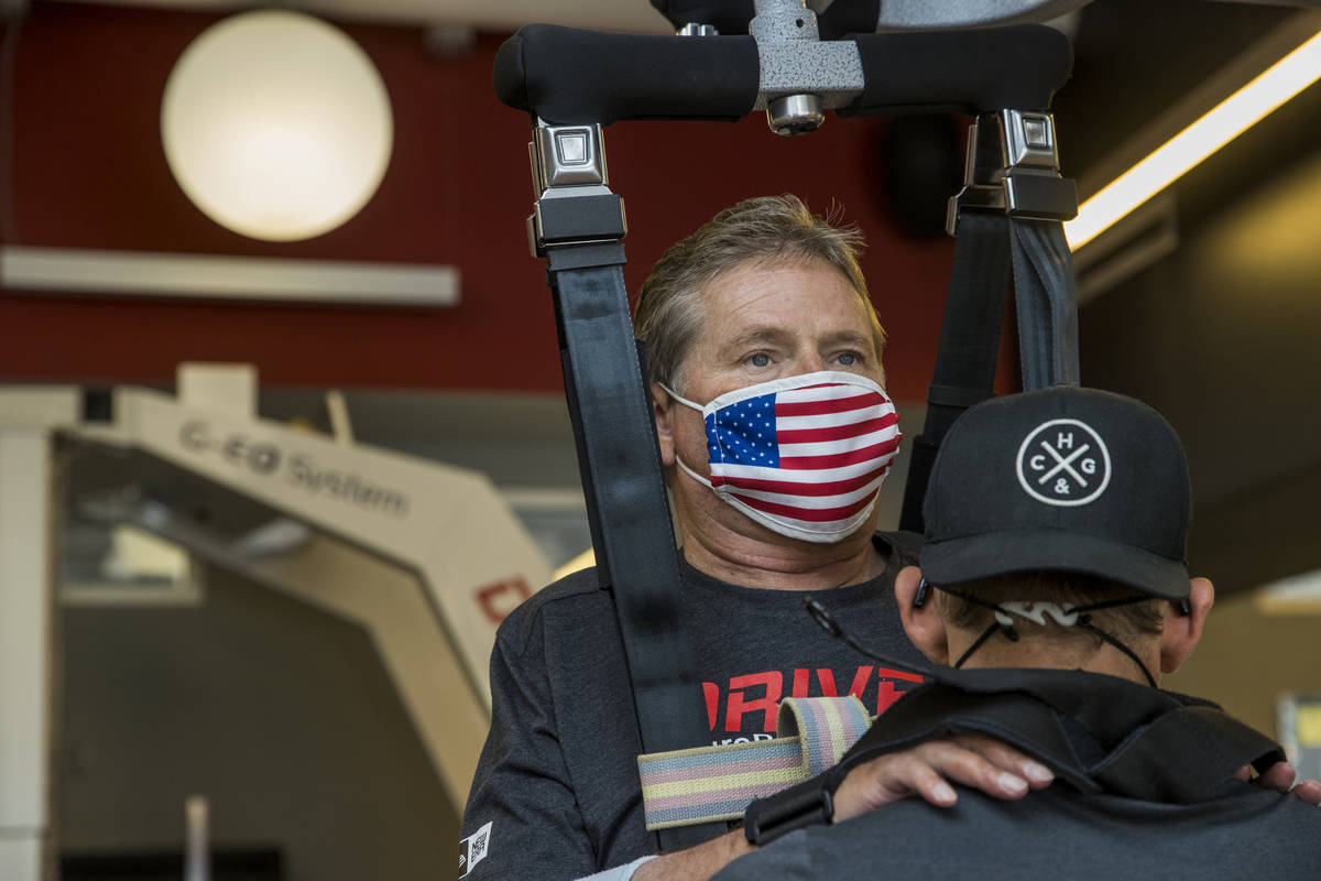 Quadriplegic IndyCar team owner Sam Schmidt, left, is given neuromuscular electrical and vibrat ...
