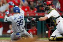Los Angeles Dodgers' Cody Bellinger (35) scores against Cincinnati Reds catcher Curt Casali, ri ...