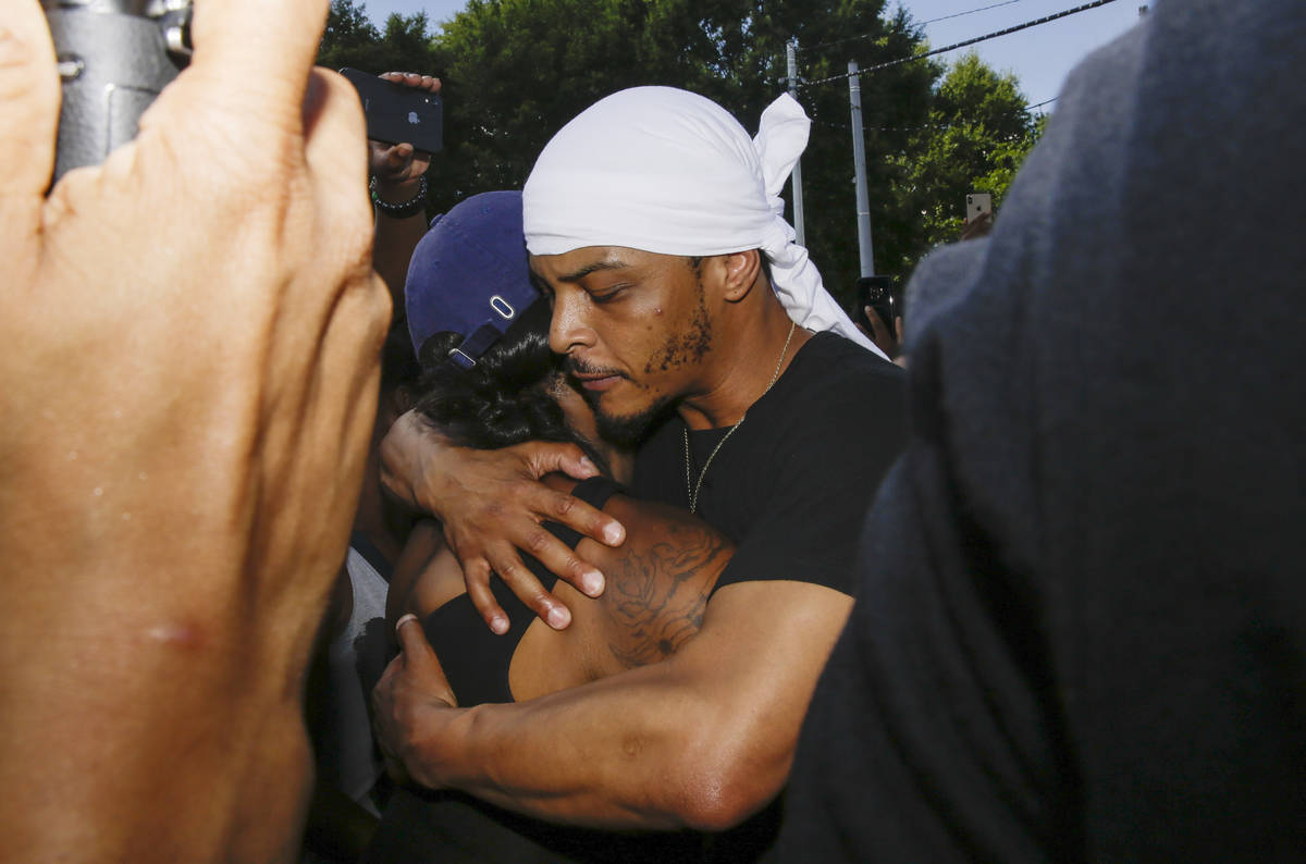 Rapper T.I. hugs a family member of Rayshard Brooks during protests, Saturday, June 13, 2020, n ...
