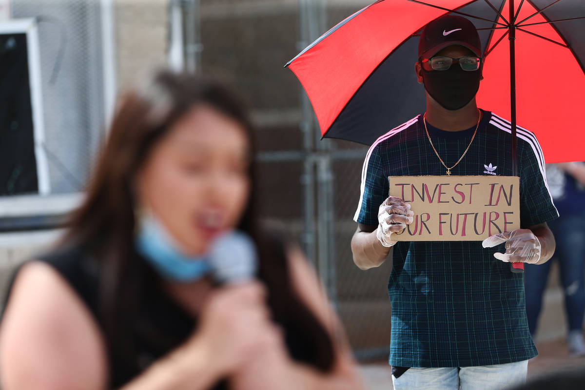 Adam Allen, 18, who graduated this year from Canyon Springs High School, holds a sign during a ...