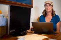 Elizabeth Michael-Martin sits at her kitchen table where she would normally work when at home i ...
