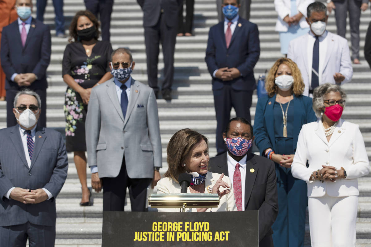 House Speaker Nancy Pelosi of Calif., joined by House Democrats spaced for social distancing, s ...