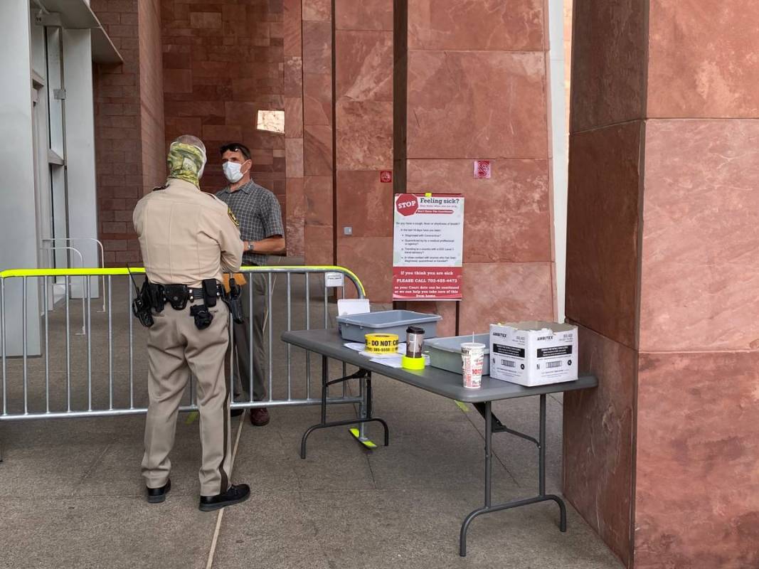 Masked marshals guarded the entrance to the Regional Justice Center, where a mask order has bee ...