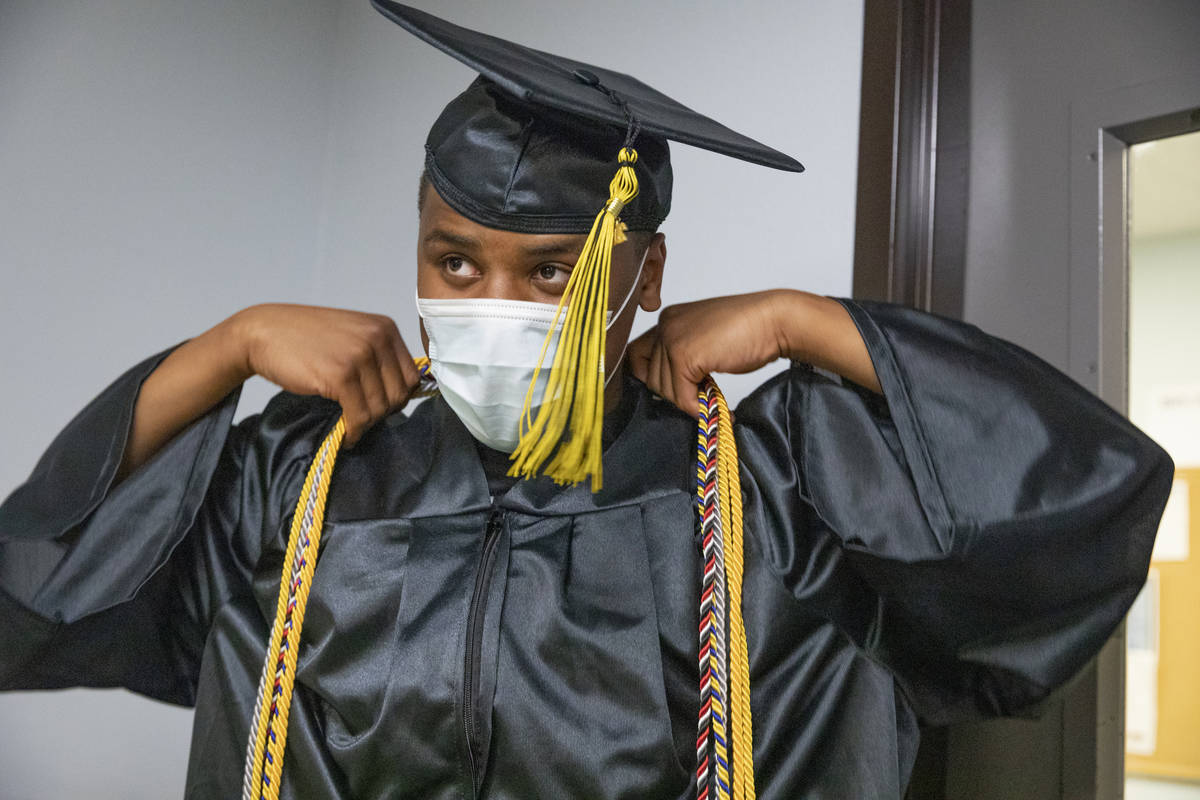 Jaden Hines, 18, a graduate of Nevada State High School, puts on his cap and gown for a graduat ...