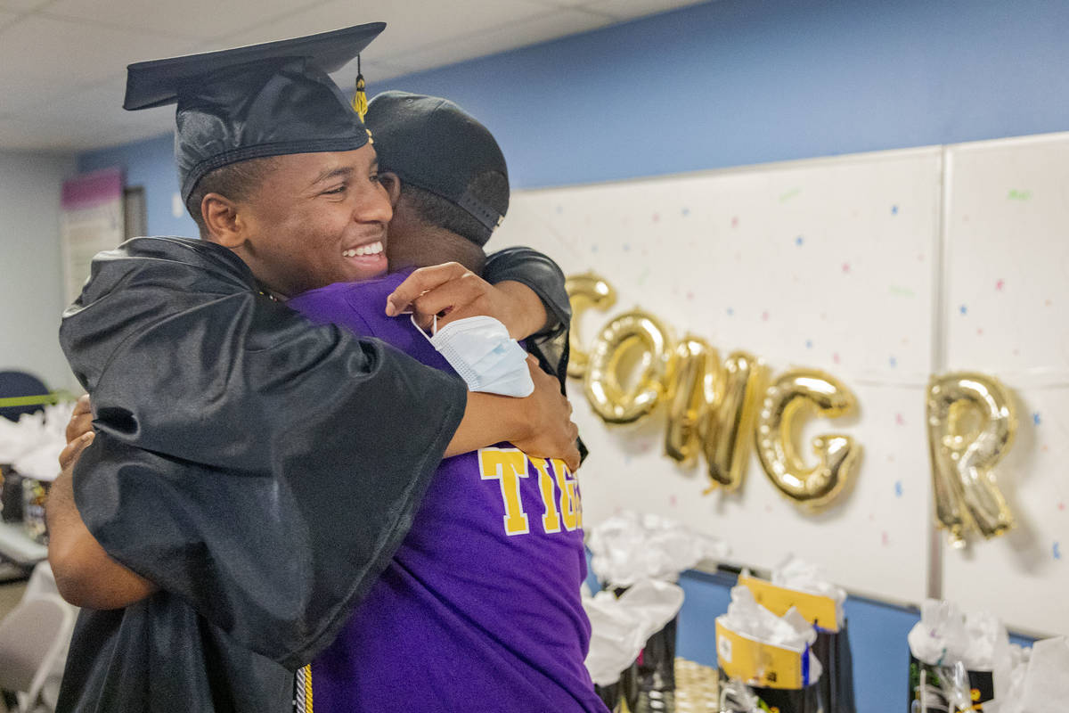 Jaden Hines, 18, a graduate of Nevada State High School, left, hugs his foster parent Joseph Wi ...