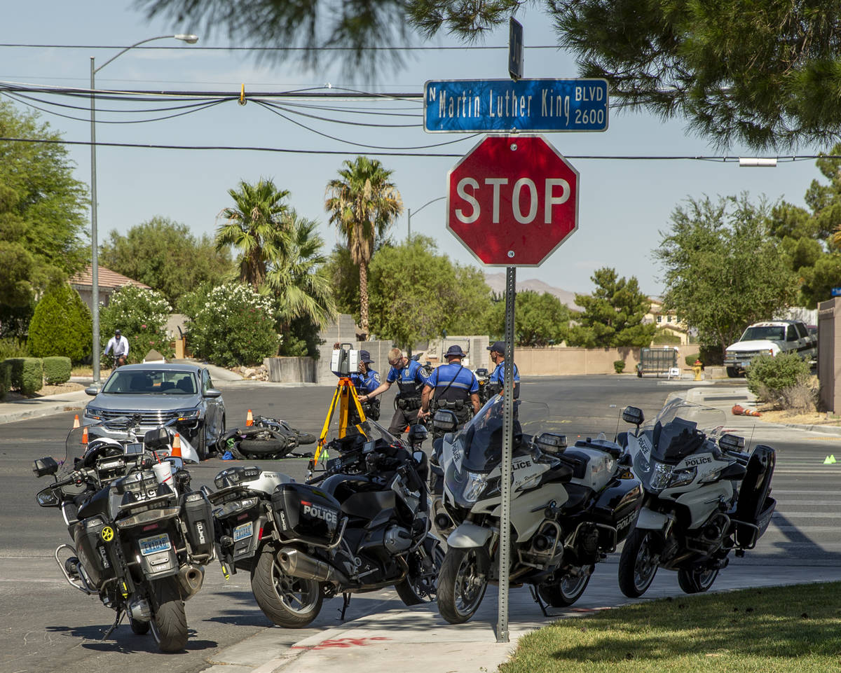 A Major Crash Investigation Unit records the scene of a downed motorcycle and car collision as ...