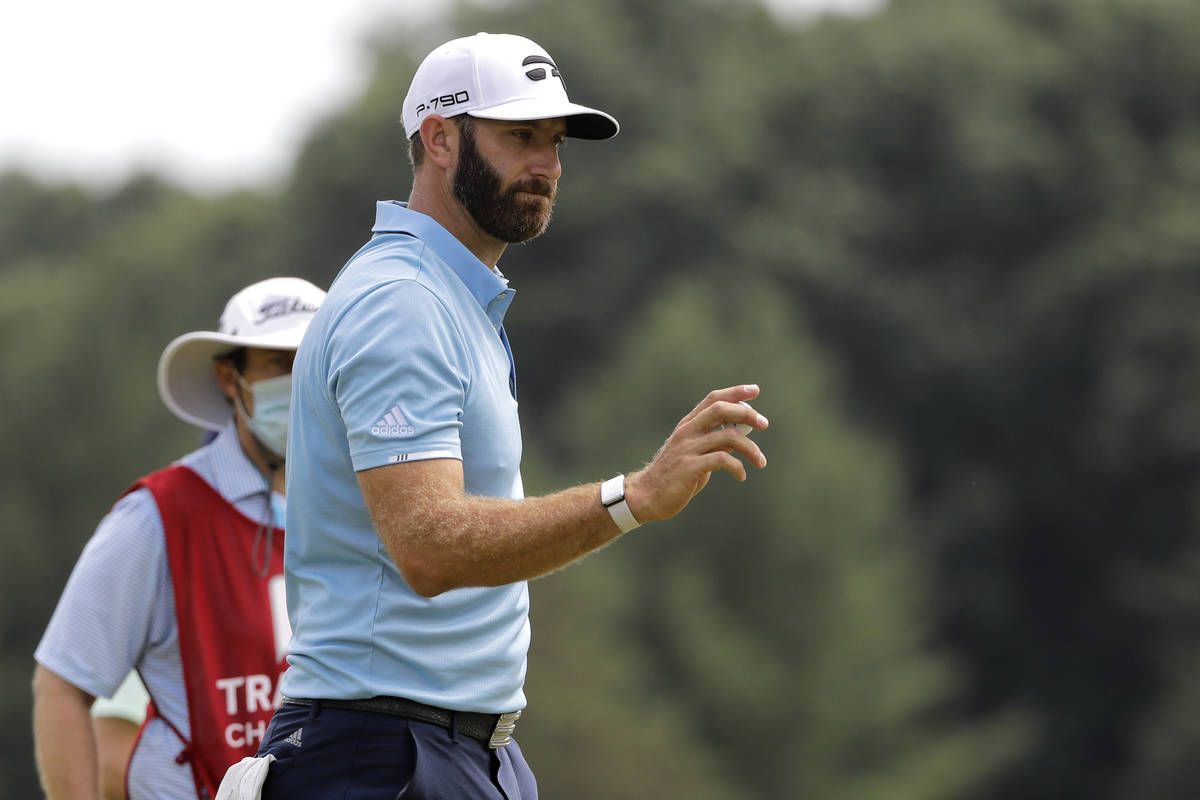 Dustin Johnson acknowledges people on the homes along the fifth green after putting during the ...