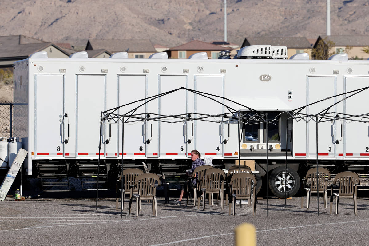 Workers set up showers at Centennial High School in Las Vegas as part of a base camp for firefi ...