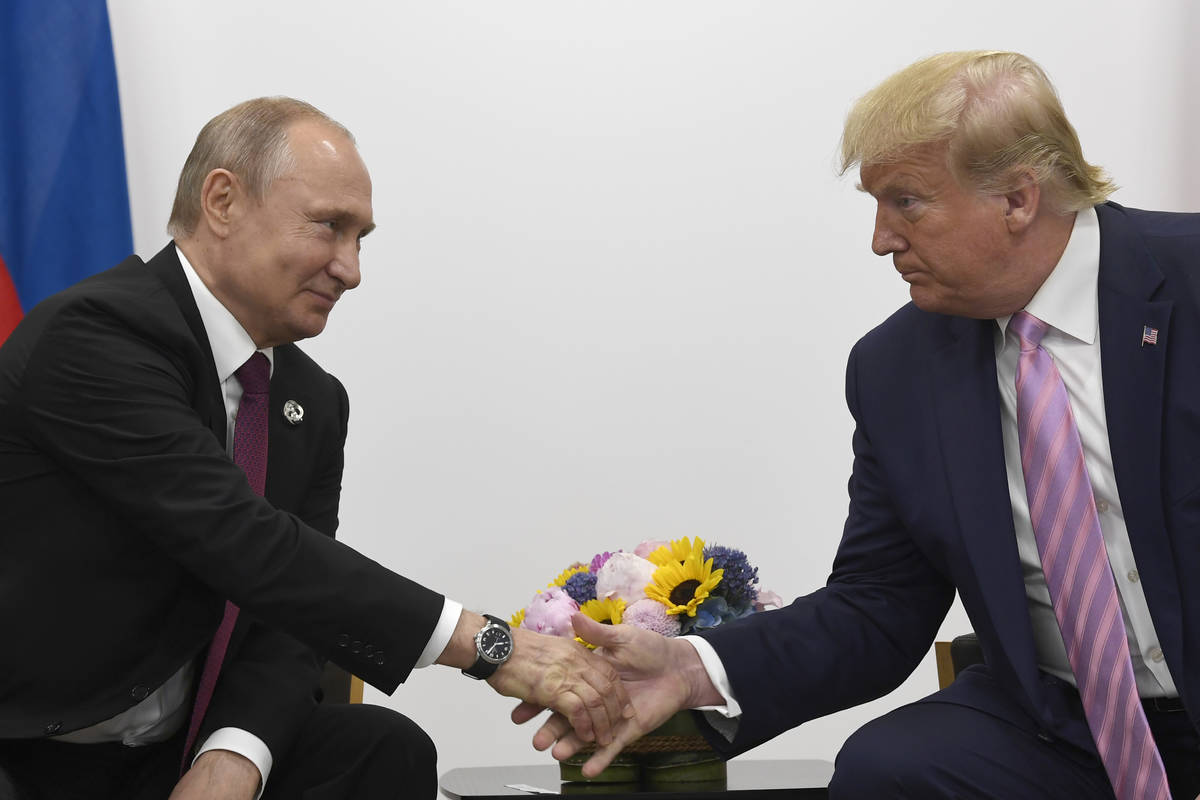 FILE - In this June 28, 2019, file photo President Donald Trump, right, shakes hands with Russi ...
