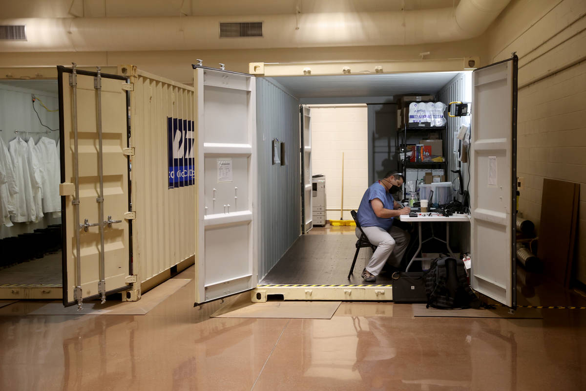 A worker in an administrative container at the Battelle Critical Care Decontamination System si ...
