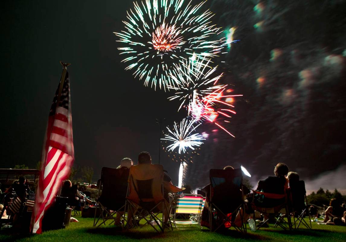 FILE - In this July 4, 2013, file photo, people watch as fireworks explode overhead during the ...