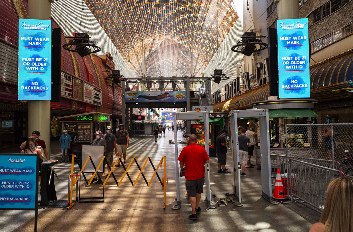 People walk through temperature scanners at the Fremont Street Experience in downtown Las Vegas ...