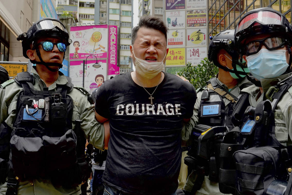 Police detain a protester after spraying pepper spray during a protest in Causeway Bay before t ...